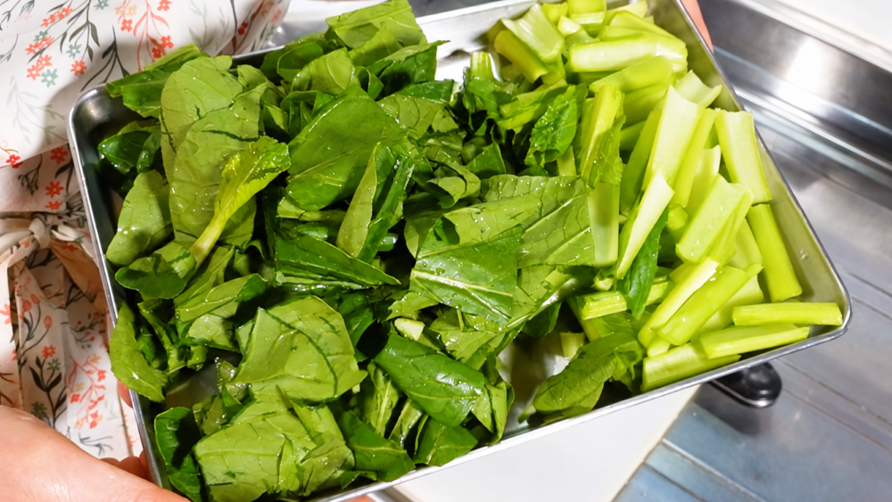 食べやすい大きさに切った小松菜の葉と茎をバットに分けた様子