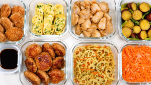 卵焼きや肉のおかず、野菜の副菜など7品をガラス保存容器に並べた作り置き